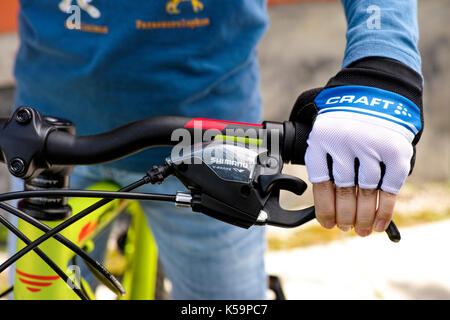 Tambov, Russian Federation - May 07, 2017 Child hand with Craft glove on handlebars with Shimano speed shift and brake lever. Stock Photo