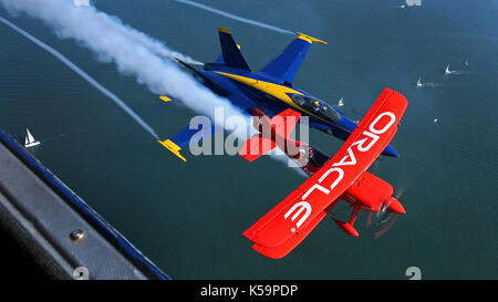 US Marine Corps Major Nathan Miller fly his F/A-18 Blue Angel #5 jet in position near Sean Tucker's Oracle Challenger bi-plane Oct. 8, 2009 in SF Stock Photo