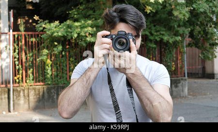 Handsome young male photographer taking photograph Stock Photo