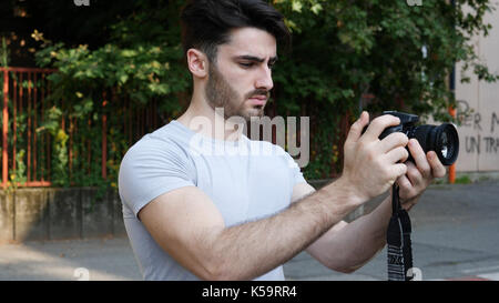 Handsome young male photographer shooting video Stock Photo