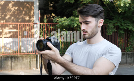 Young man posing with photo camera Stock Photo