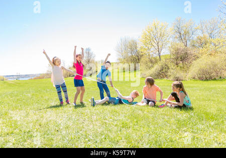 Group of child have fun on a field with rope Stock Photo