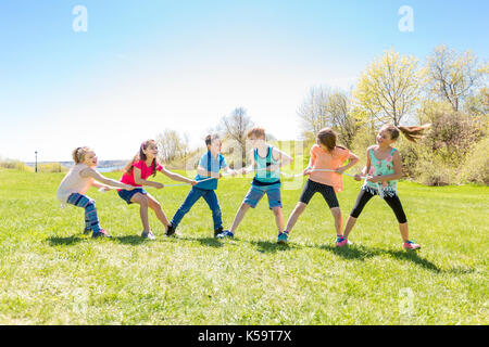 Group of child have fun on a field with rope Stock Photo