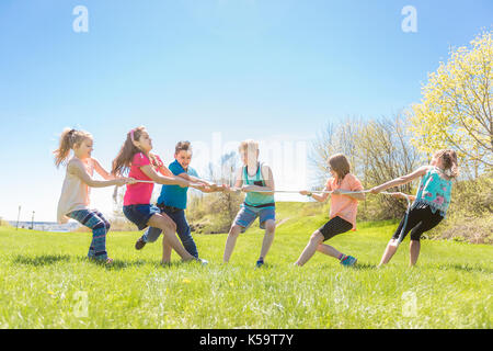 Group of child have fun on a field with rope Stock Photo