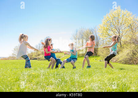 Group of child have fun on a field with rope Stock Photo