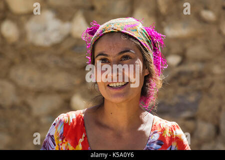 Close up portrait of smiling Pamiri / Badakhshani woman wearing colourful head scarf, Gorno-Badakhshan province, Tajikistan Stock Photo