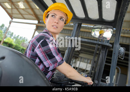 portrait of female fork lift truck driver in warehouse Stock Photo