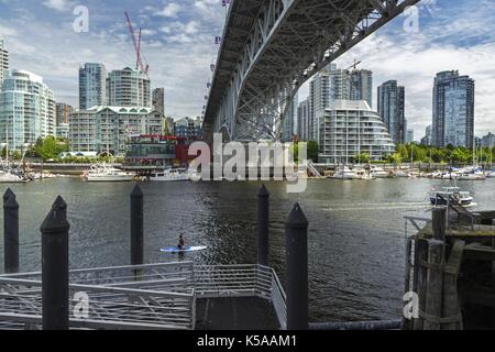 Granville Island Pier under Granville Bridge looking across False Creek to Yaletown City Center Highrise Buildings, Vancouver British Columbia Canada Stock Photo