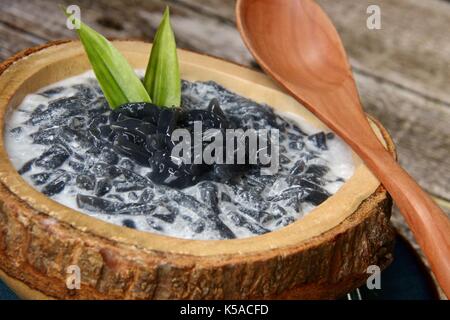 Es Dawet Ireng. Javanese cold dessert of roasted paddy straw jelly, served with coconut milk and palm sugar. Stock Photo