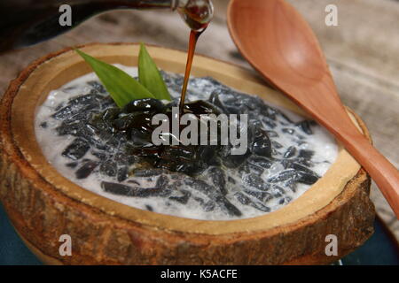 Es Dawet Ireng. Javanese cold dessert of roasted paddy straw jelly, served with coconut milk and palm sugar. Stock Photo