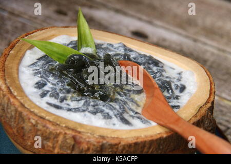 Es Dawet Ireng. Javanese cold dessert of roasted paddy straw jelly, served with coconut milk and palm sugar. Stock Photo