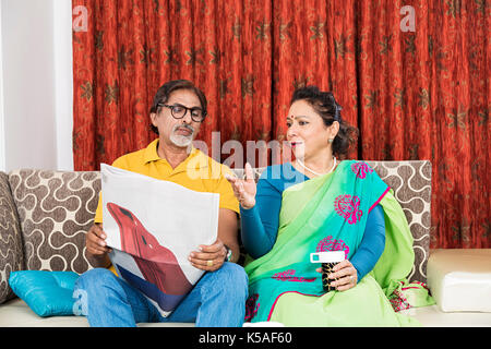 Senior couple reading newspaper while having morning tea together Stock Photo