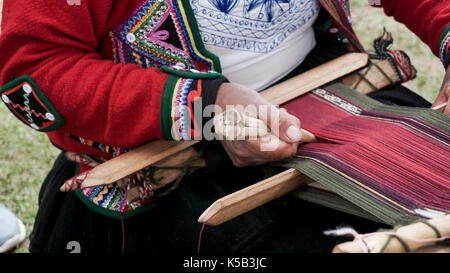 A Quechuan woman demsontrates alpaca wool weaving. Stock Photo