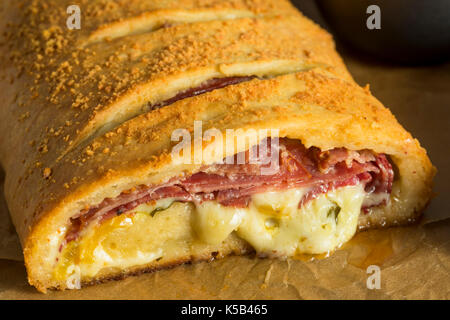 Homemade Cheesy and Meaty Italian Stromboli with Marinara Sauce Stock Photo