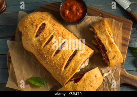 Homemade Cheesy and Meaty Italian Stromboli with Marinara Sauce Stock Photo