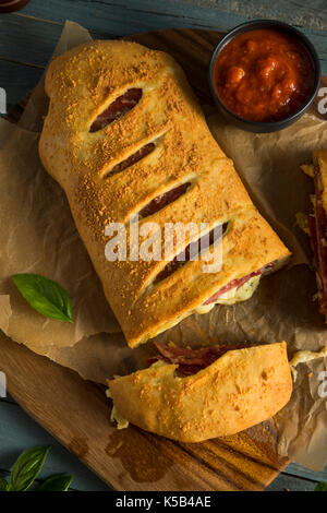 Homemade Cheesy and Meaty Italian Stromboli with Marinara Sauce Stock Photo