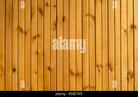 background: a section of the wall lined with yellow lacquered wooden slats Stock Photo