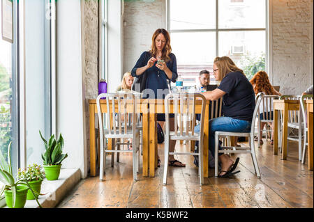 Patrons at a coffee shop in a large metropolitan city Stock Photo