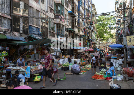 Many kind of fresh vegetables being sold and people at a street market on the 26th street in downtown Yangon, Myanmar (Burma). Stock Photo