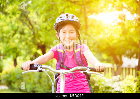 Happy girl  riding bicycle in the park Stock Photo