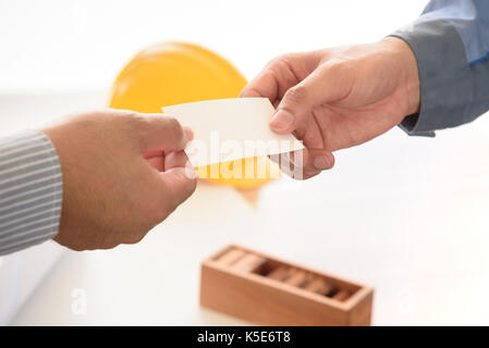 exchanging business card with engineering tools background, selective focus Stock Photo