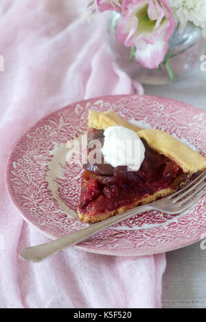 Galette with plums and cream. Rustic style, selective focus. Stock Photo