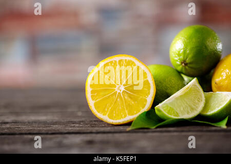 Stack of citrus fruits sliced. lemons and limes on wooden table Stock Photo