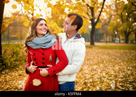 Nice young people in love embraced in park in autumn Stock Photo
