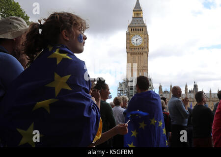 London, UK. 9th Sept, 2017. A girl wrapped in an EU flag stands in Parliament Square Garden in Westminster, central London, during the People's March for Europe, an anti-Brexit rally, on 9 September 2017. The clock tower of Big Ben is in the background. Credit: Dominic Dudley/Alamy Live News Stock Photo