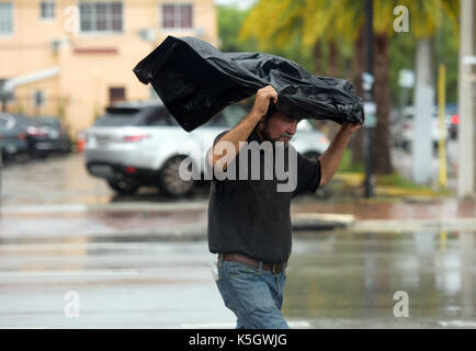 Miami, USA. 9th Sep, 2017. A man walks in rain as hurricane 'Irma' is approaching, in Miami, Florida, the United States, Sept. 9, 2017. About 5.6 million people in Florida have been ordered to evacuate, while 54,000 Floridians have taken shelter in 320 shelters across Florida. Forecasters expect the hurricane to hit Florida early Sunday morning. Credit: Yin Bogu/Xinhua/Alamy Live News Stock Photo