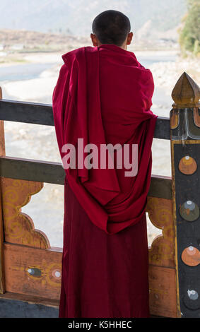 Buddhist monk looking at the river at Punakha Dzong, Western Bhutan, during the annual Drubchen and Tsechu. Stock Photo