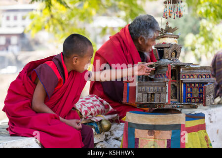 Monk collecting alms outside Punakha Dzong during the annual Tsechu (religious festival) Western Bhutan Stock Photo