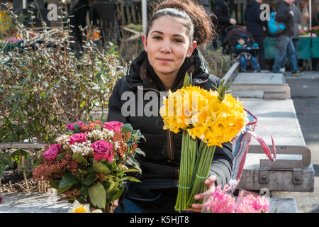 Girl selling flowers in spring at the Bastille market, Paris. France Stock Photo