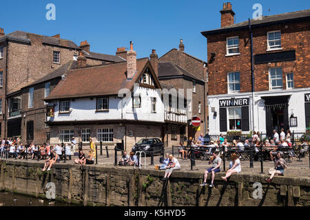 People sat outdoors at the bars and cafes along the banks of the River Ouse in York on a summers day, Yorkshire, England, UK Stock Photo