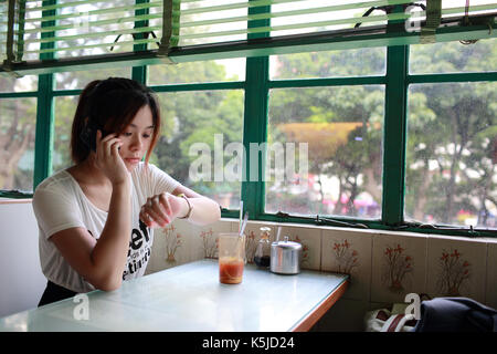 Beautiful chinese Girl waiting someone so long and feeling bad, She rested her chin on her hand in hong kong china Stock Photo