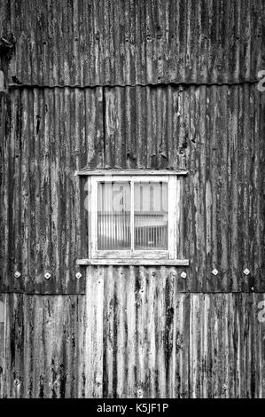 rusty corrugated iron building, warehouse with window. Stock Photo