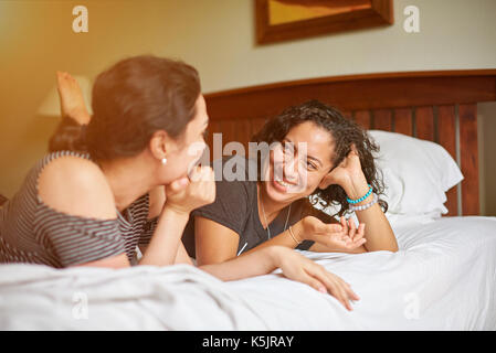 Two younf woman talk laying on bed Stock Photo