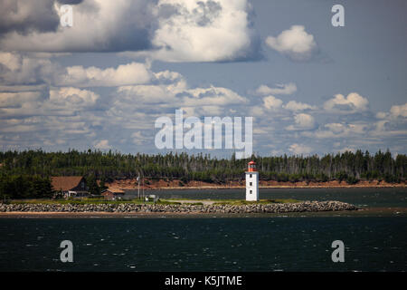 A lighthouse sits on the north western shoreline of Nova Scotia, Canada as seen from a passenger ferry crossing the Northumberland Straight. Stock Photo