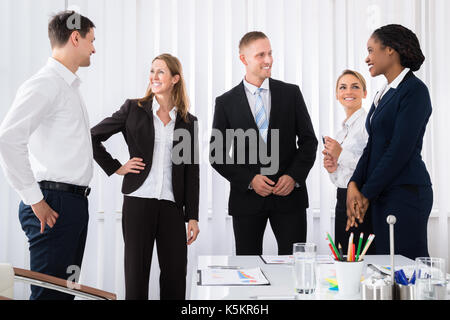 Happy Successful Businesspeople Having Conversation In Office Stock Photo