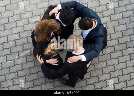 High Angle View Of Businesspeople Standing In Huddle Stock Photo