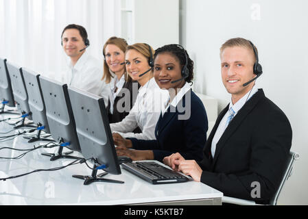 Team Of Businesspeople With Headsets Working In Call Center Office Stock Photo