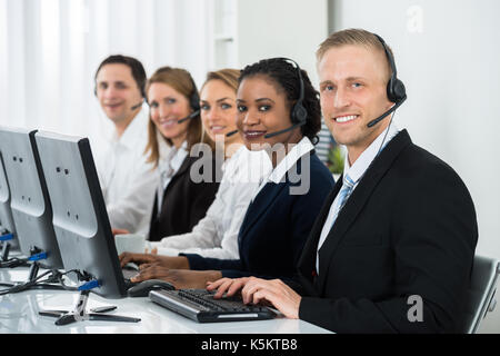 Team Of Businesspeople With Headsets Working In Call Center Office Stock Photo