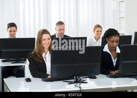 Happy Group Of Businesspeople Working On Computers In Office Stock Photo