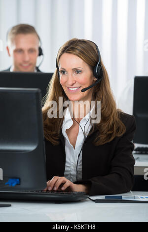 Happy Female Call Center Executive Working On Computer In Office Stock Photo