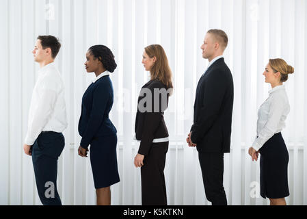 Group Of Businesspeople Doing Various Activities While Waiting For Interview Stock Photo