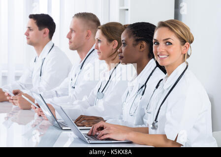 Happy Female Doctor Working With Her Colleagues In Hospital Stock Photo