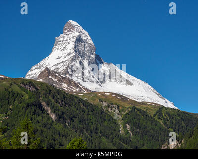 Matterhorn peak in sunny day with pine tree mountain in foreground,  Zermatt, Switzerland. Stock Photo