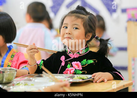 (170910) -- BEIJING, Sept. 10, 2017 (Xinhua) -- Pan Chengyue, a 4-year-old girl of Miao ethnic group, takes free lunch at the Kaihuai Community No. 13 Kindergarten, which was newly built for children relocated from poverty-stricken areas, in Kaili City, Miao and Dong Autonomous Prefecture of Qiandongnan, southwest China's Guizhou Province, Sept. 6, 2017. Nutrition program has benefited preschool children in rural area of Kaili since spring this year, with free breakfast and lunch offered to children at rural kindergartens and kindergartens for children relocated from poverty-stricken areas. (X Stock Photo