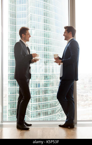Male coworkers enjoying cup of coffee during break Stock Photo