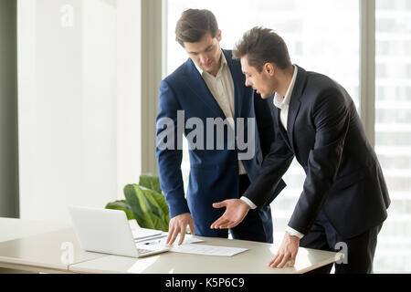 Architects discussing construction plan drawings Stock Photo